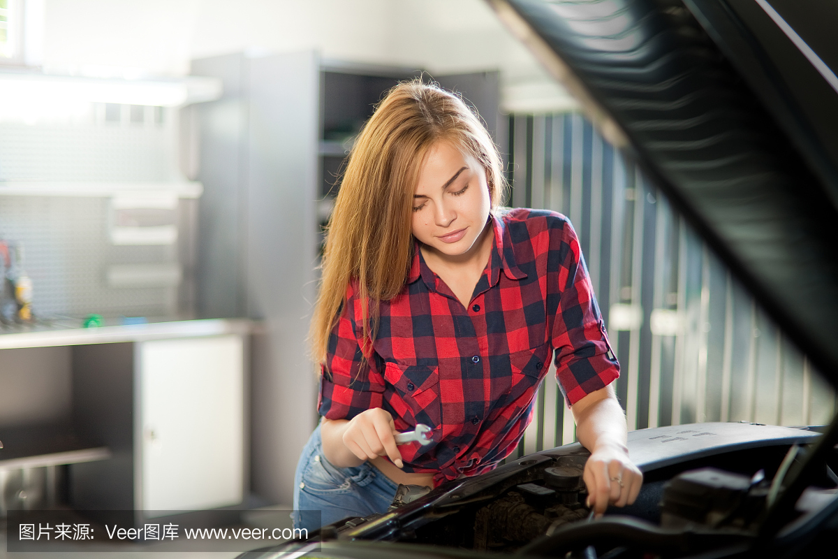 年輕性感的褐發(fā)機(jī)修工穿著格子襯衫在車庫(kù)里。